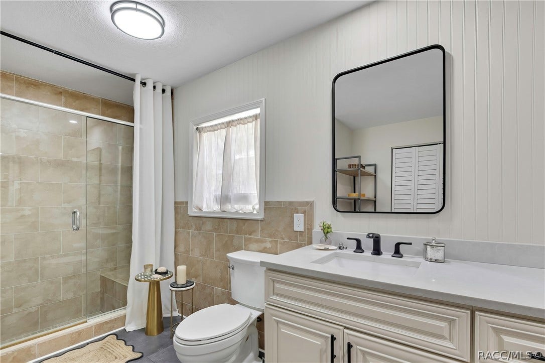 11806 W Riverhaven Drive, Homosassa, FL 34448 Bathroom with shower, toilet, and vanity.