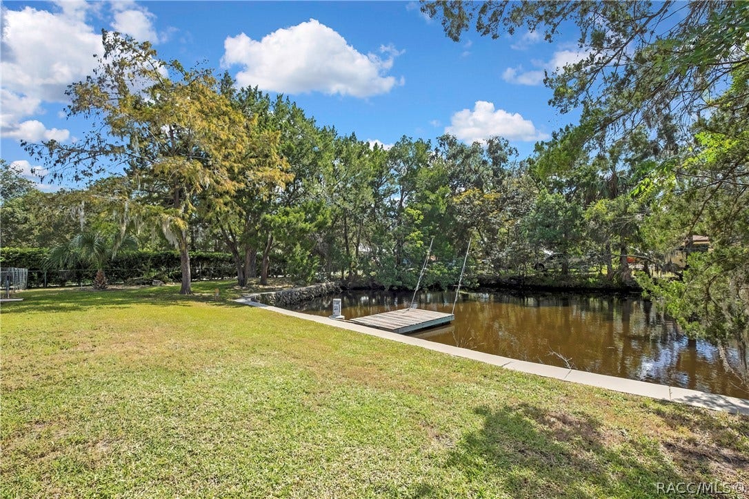 11806 W Riverhaven Drive, Homosassa, FL 34448 Backyard lawn sloping to the canal.