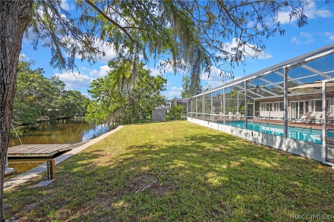 11806 W Riverhaven Drive, Homosassa, FL 34448 Backyard between the pool enclosure and the canal.
