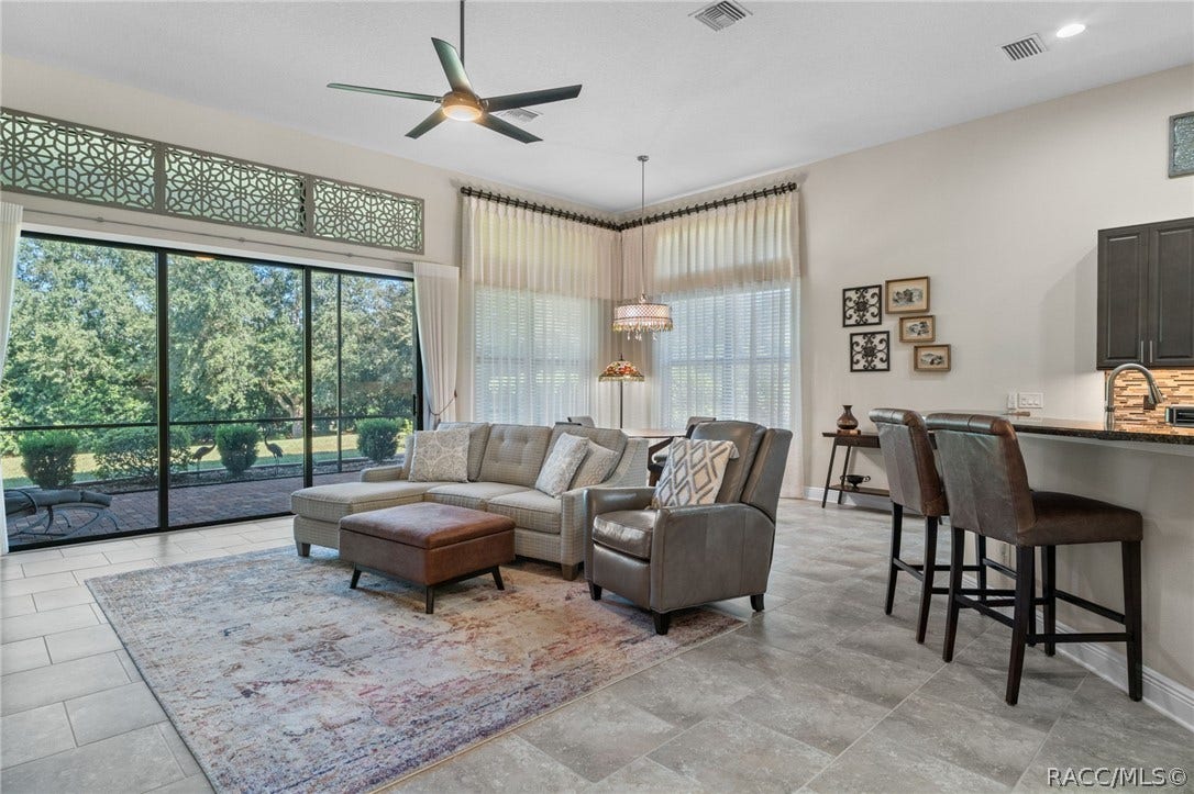 The spacious great room combines living and dining and is flanked by the breakfast bar and spacious kitchen.