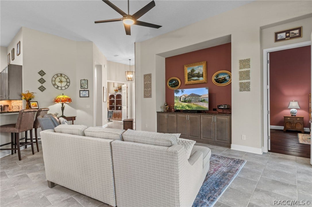 The greatroom features a built-in entertainment center with granite top, provides additional storage and becomes the focal point of the room. The doorway on the right leads into the primary suite.