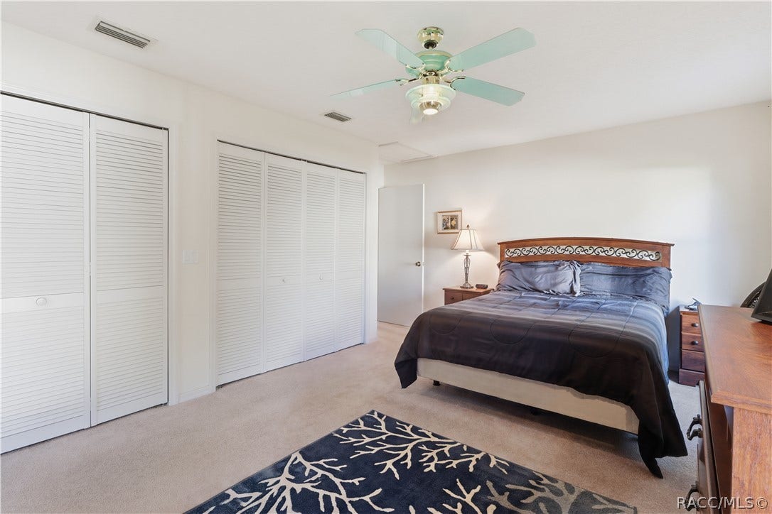 ROOM TO RELAX! PRIMARY SUITE features GENEROUS CLOSET SPACE w/multiple louvered closet doors, soft neutral carpeting & ceiling fan!
