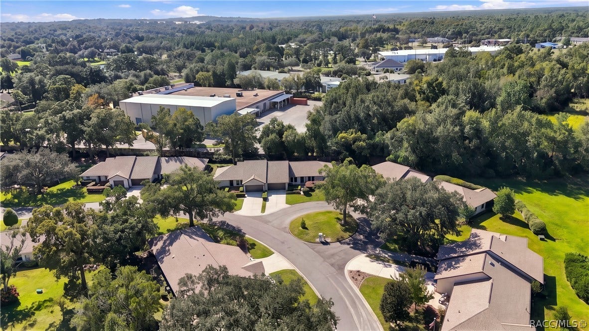 Elevated neighborhood view highlighting the cul-de-sac location, surrounding homes, mature trees, and nearby development.