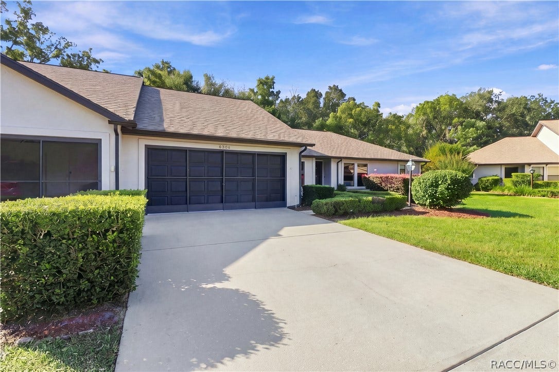 PULL RIGHT IN! Spacious CONCRETE DRIVEWAY leads to the attached 2-CAR GARAGE, surrounded by lush green lawn & attractive landscaping!