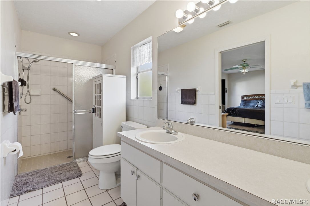 EVERYDAY COMFORT! PRIMARY BATH features a spacious VANITY, LARGE MIRROR, WALK-IN SHOWER & convenient storage!