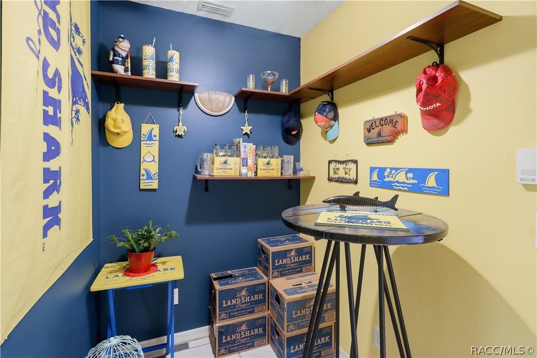 Versatile bonus room featuring built-in wall shelving and space for a small table, hobby area, or personal retreat.