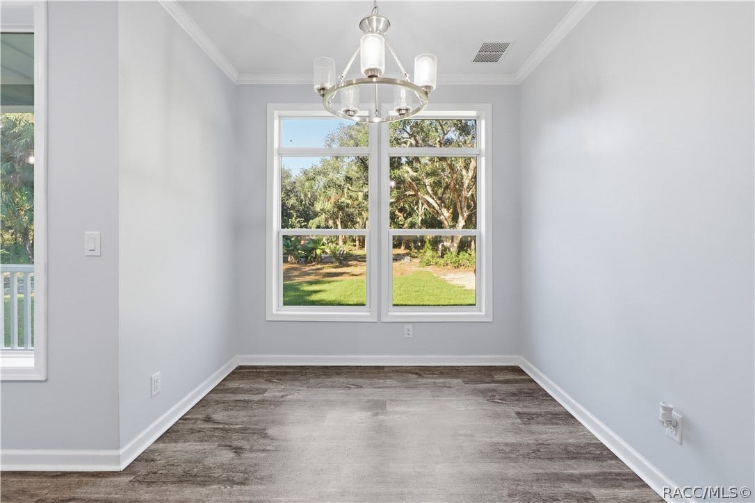 7528 N Chabaud Terrace, Crystal River, FL 34428 GATHER AROUND THE TABLE! The DINING AREA features a contemporary chandelier, attractive flooring & large windows framing views of the wooded property.