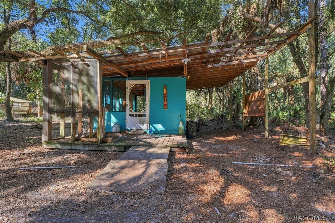 7528 N Chabaud Terrace, Crystal River, FL 34428 A UNIQUE OUTDOOR SPACE! A closer view of the rustic structure showcases its wooden deck, screened section & extended overhead framework.