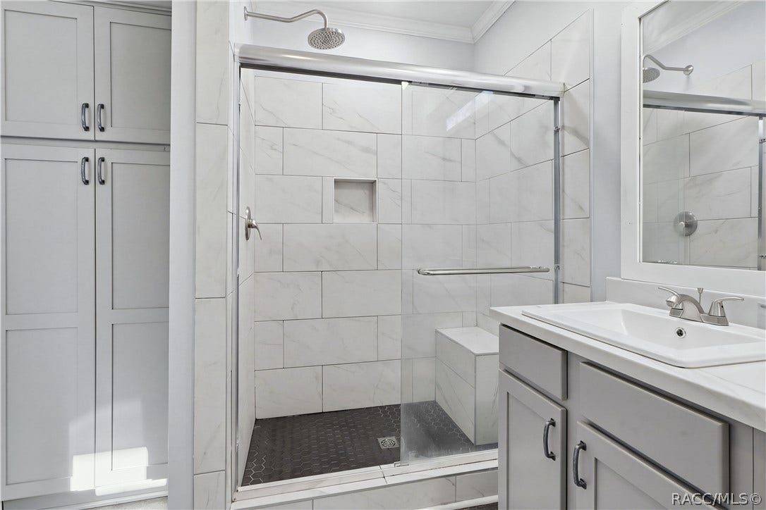 7528 N Chabaud Terrace, Crystal River, FL 34428 A SHOWER DESIGNED FOR COMFORT! The WALK-IN SHOWER features marble-look tile, a rainfall-style showerhead, glass sliding doors, built-in seating & a convenient recessed niche.