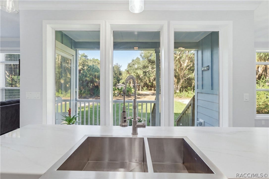 7528 N Chabaud Terrace, Crystal River, FL 34428 IT'S ALL IN THE DETAILS! A stylish GRAY GEOMETRIC TILE BACKSPLASH, electric cooktop & modern stainless steel range hood add personality to the kitchen.