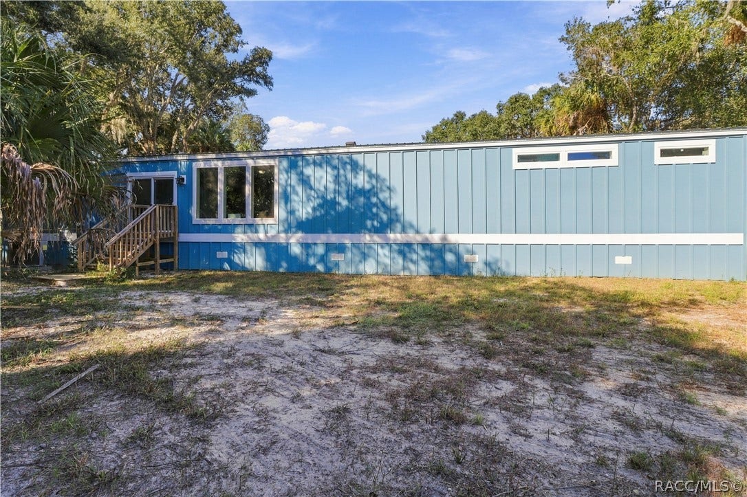 7528 N Chabaud Terrace, Crystal River, FL 34428 COUNTRY CHARM & ROOM TO ROAM! Another exterior view showcases the home's spacious setting, attractive siding, rear steps & surrounding greenery.