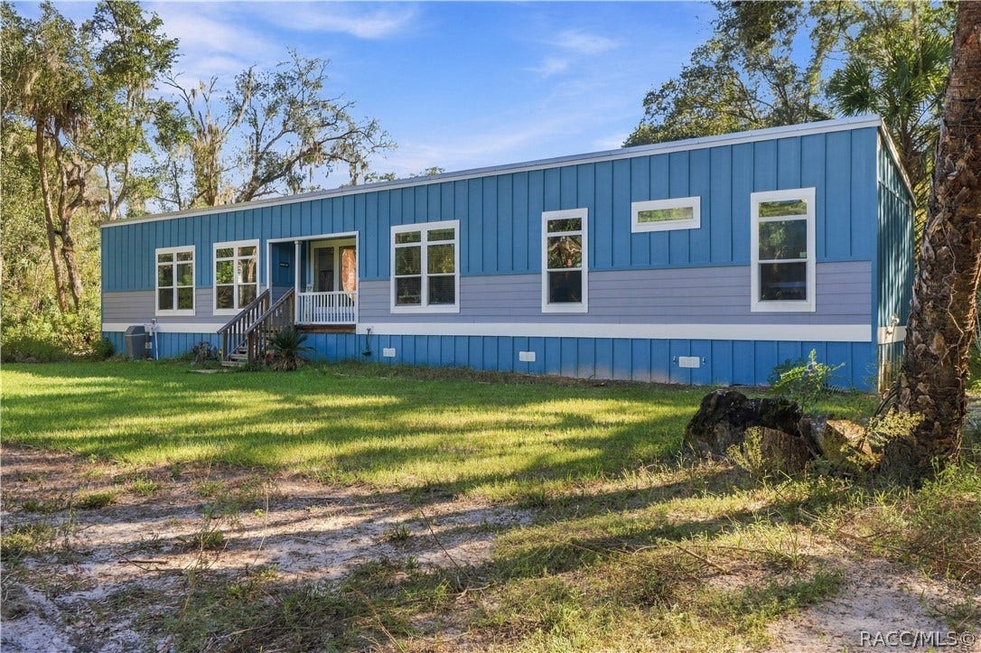 7528 N Chabaud Terrace, Crystal River, FL 34428 COUNTRY CHARM MEETS MODERN STYLE! Built in 2024, this attractive modular home features a cheerful blue exterior, contrasting white trim & METAL ROOF, all surrounded by Florida's natural beauty.