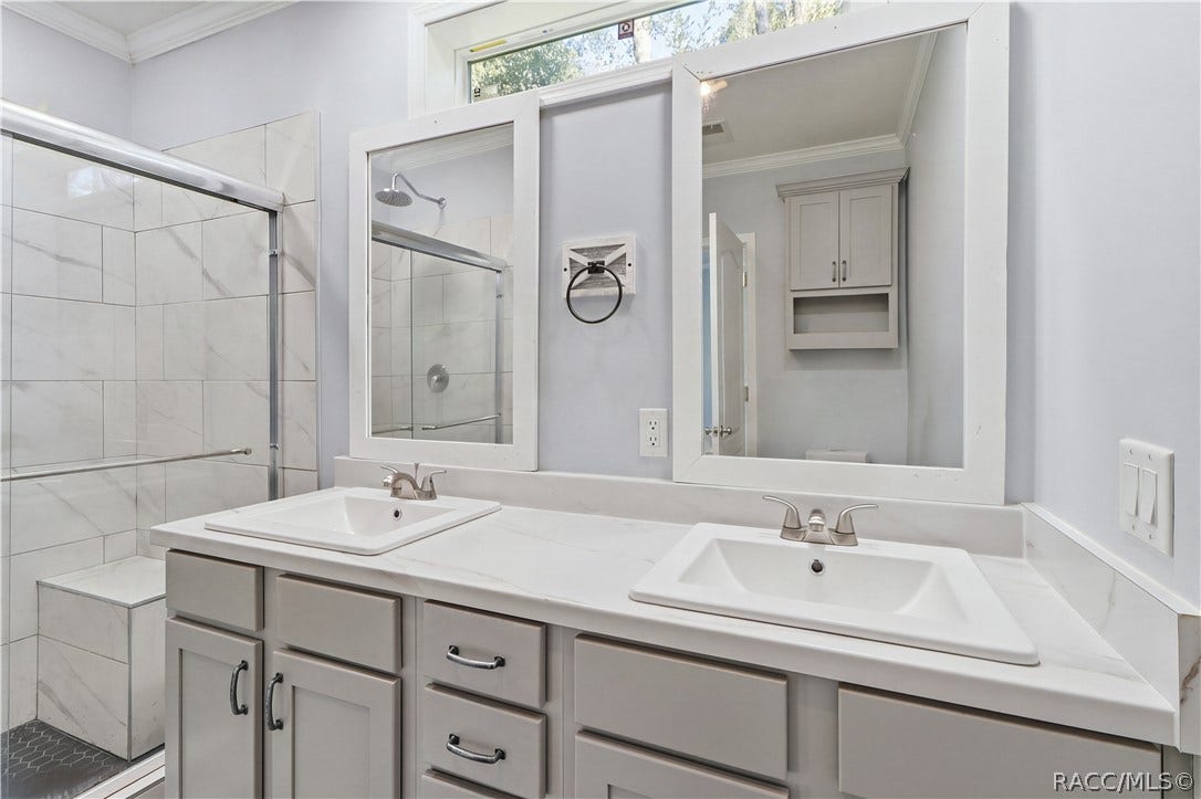 7528 N Chabaud Terrace, Crystal River, FL 34428 A BEAUTIFULLY FINISHED PRIMARY BATH! Enjoy a DOUBLE-SINK VANITY w/GRAY CABINETRY, marble-look countertops, framed mirrors & a spacious WALK-IN SHOWER.