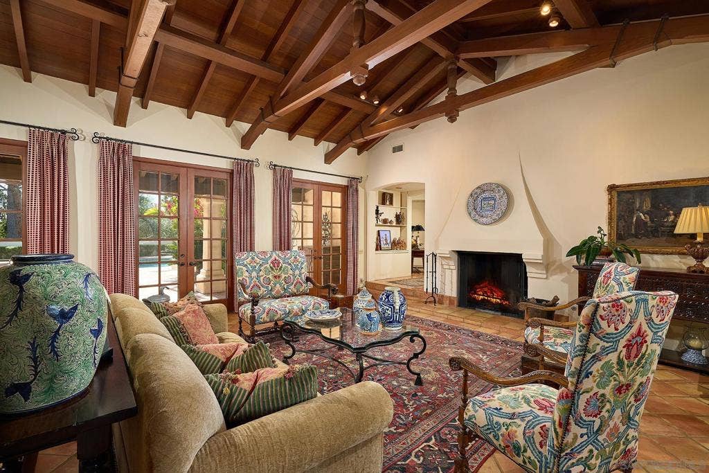 Dramatic living room with cathedral ceiling, exposed beams, and signature Rice fireplace