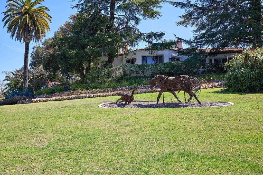 On the front lawn a barbed wire sculpture, titled Mare and Foal, by P. J. Mene with a view back to the Hahncienda and the Primary Bedroom Retreat.