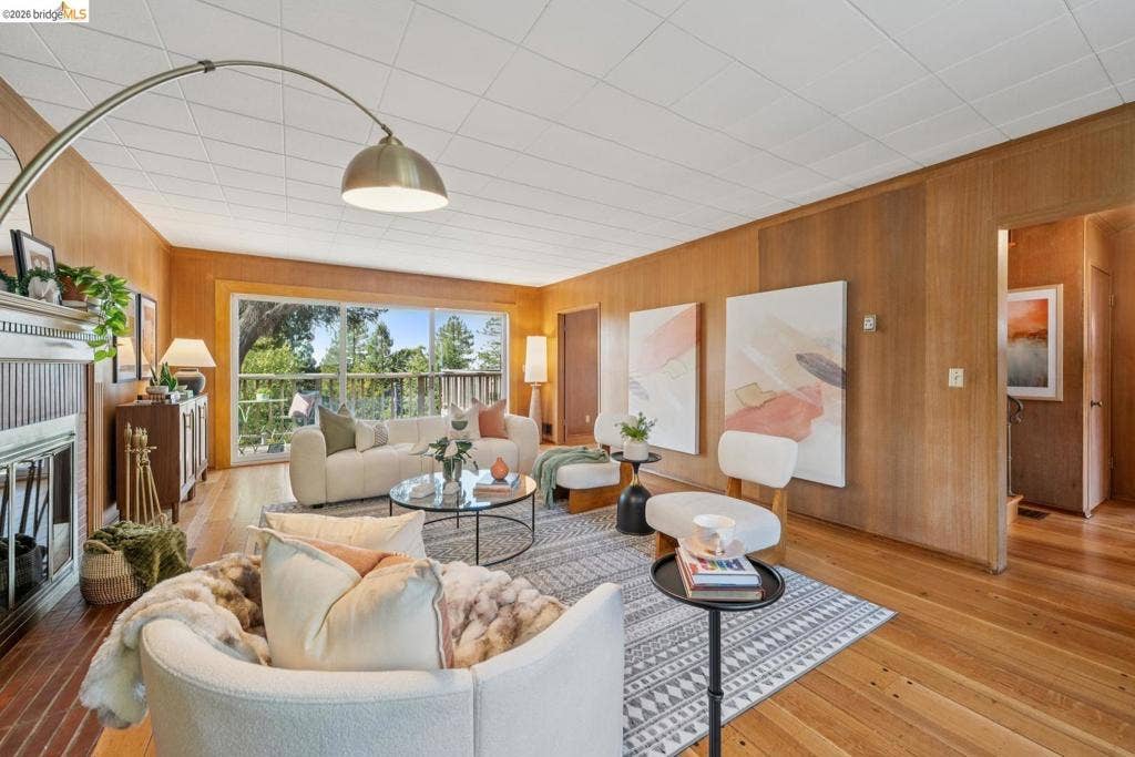 Wood-paneled walls, hardwood flooring, and a decorative fireplace