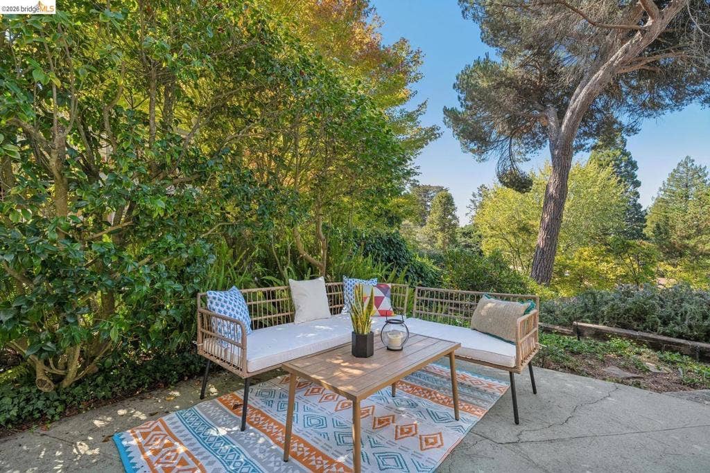 Outdoor patio area featuring a concrete surface and lush perimeter landscaping