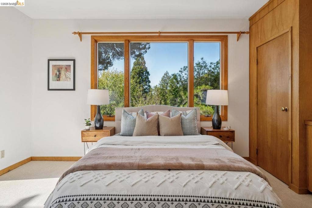 Expansive window with natural wood trim, light-colored walls, and carpeting