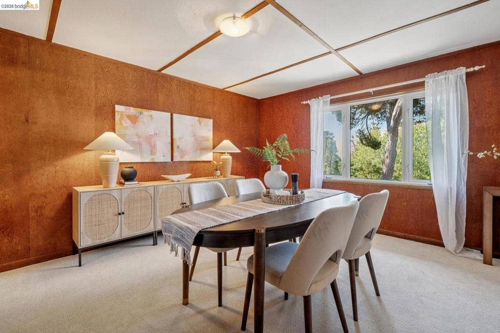 Wood-paneled accent walls, coffered ceiling, and a multiple-panel window