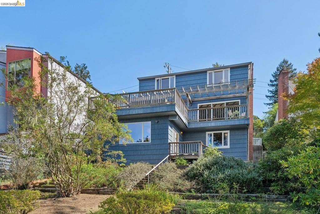 Multi-level dwelling with blue horizontal siding and multiple balconies
