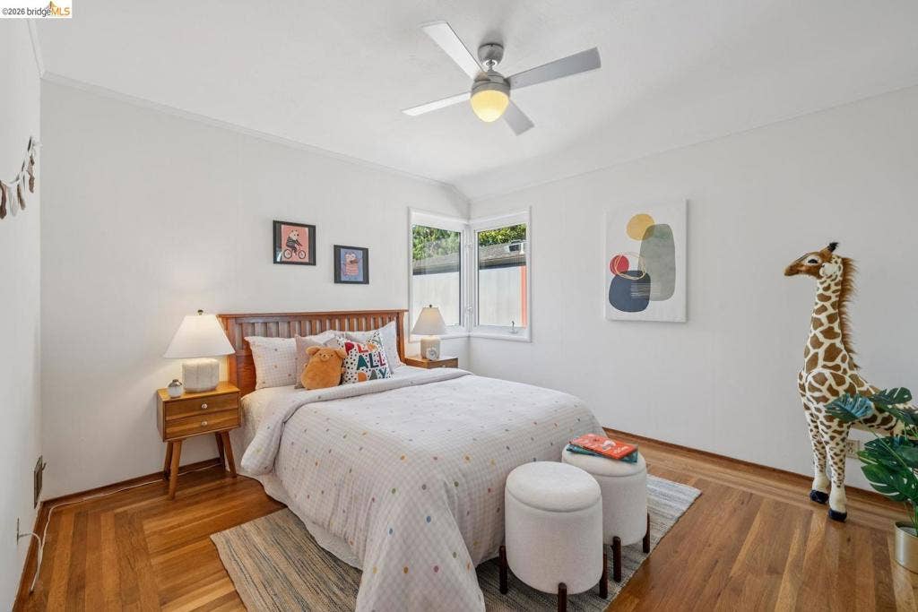 Hardwood flooring, white walls, and a ceiling fan with integrated lighting