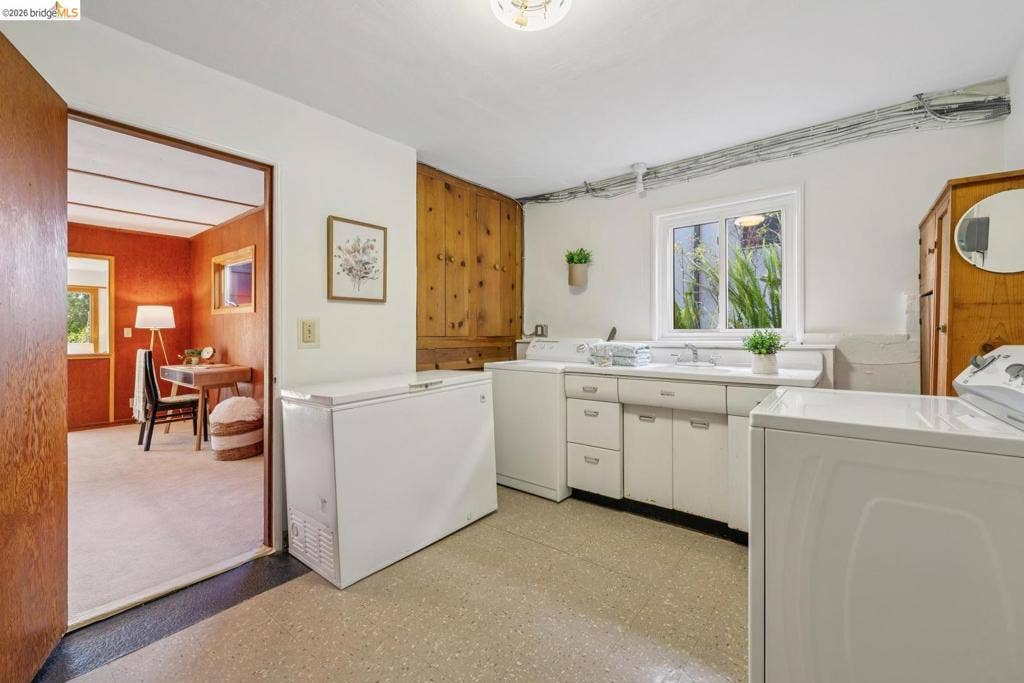 Laundry area featuring wood-finish cabinetry, white countertop, and a window