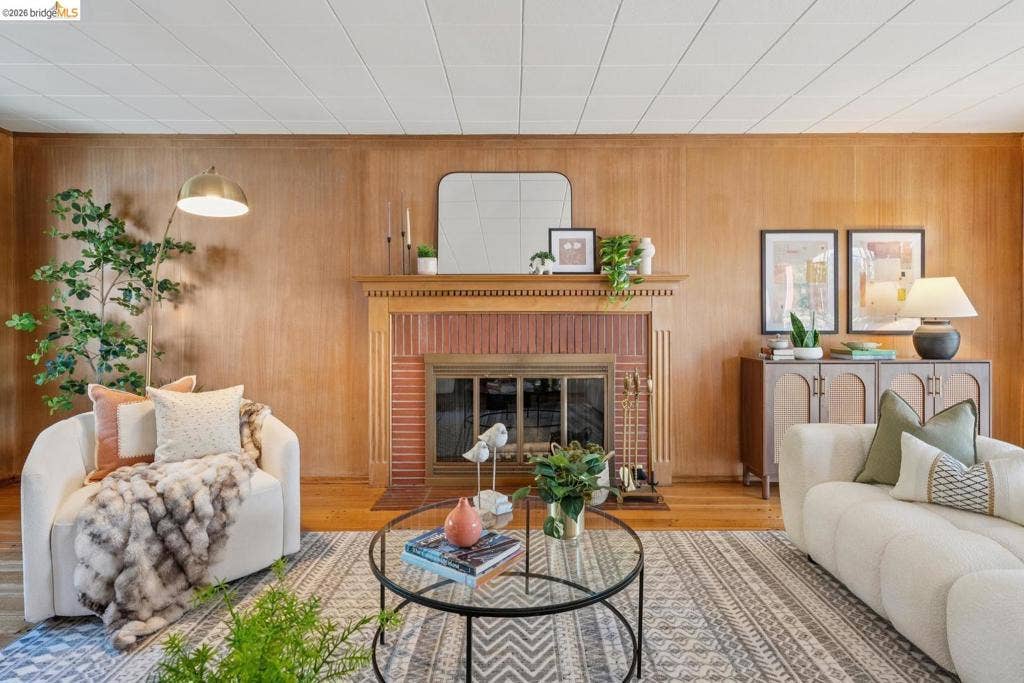 Wood-paneled accent wall with a brick fireplace and wood mantel
