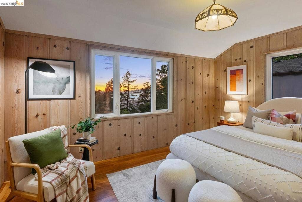 Wood-paneled walls and ceilings, wood-finish flooring, and a large window
