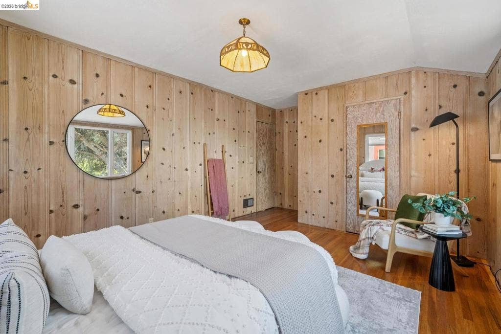 Wood paneling throughout, hardwood flooring, and a glass-paned window