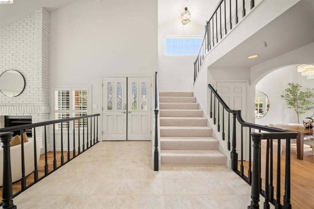 Two-story entryway featuring a vaulted ceiling and a second-story window
