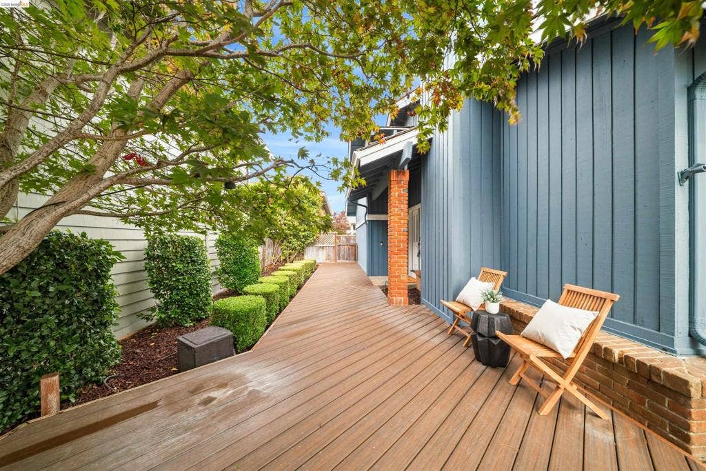 Expansive wood-finish deck with lush, manicured landscaping