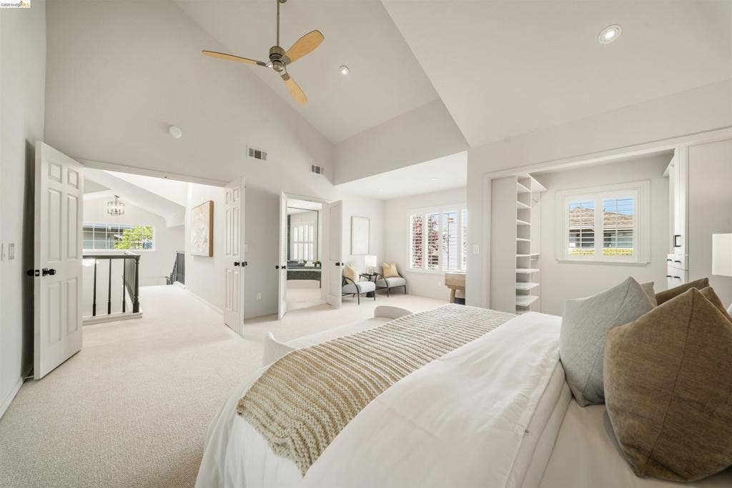 Vaulted ceilings, recessed lighting, ceiling fan, built-in shelving, and white paneled doors
