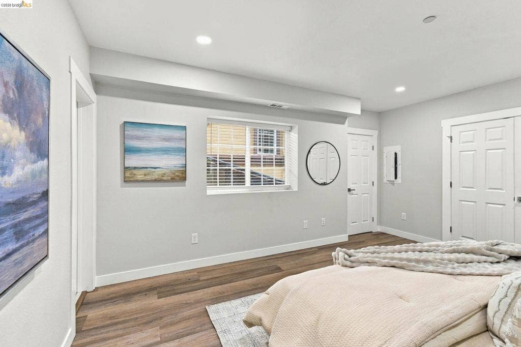 Wood-finish flooring, recessed lighting, and white trim throughout