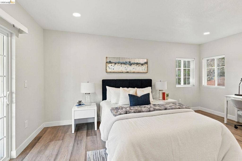 Recessed lighting, wood-finish flooring, and white walls