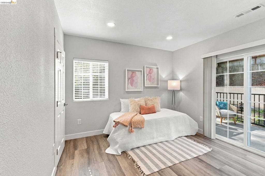 Wood-finish flooring, recessed lighting, and a sliding glass door to an outdoor space