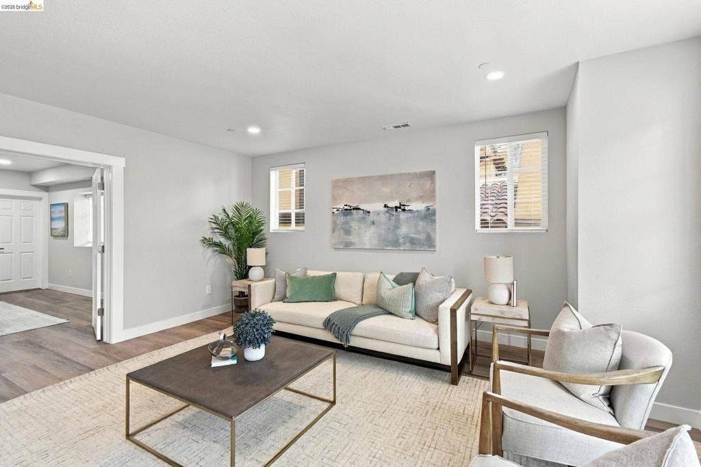 Wood-finish flooring throughout, recessed lighting, and a white trim entry