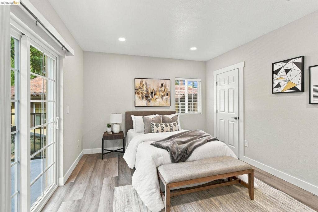 Recessed lighting, wood-finish flooring, and white trim throughout