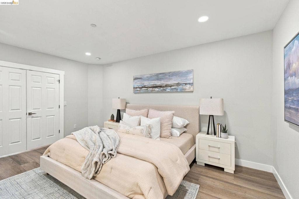 Recessed ceiling lighting, wood-finish flooring, and white paneled doors