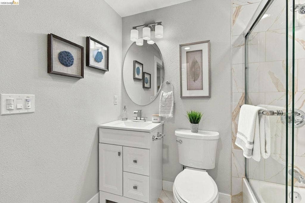 White vanity with integrated sink, chrome faucet, and overhead light fixture
