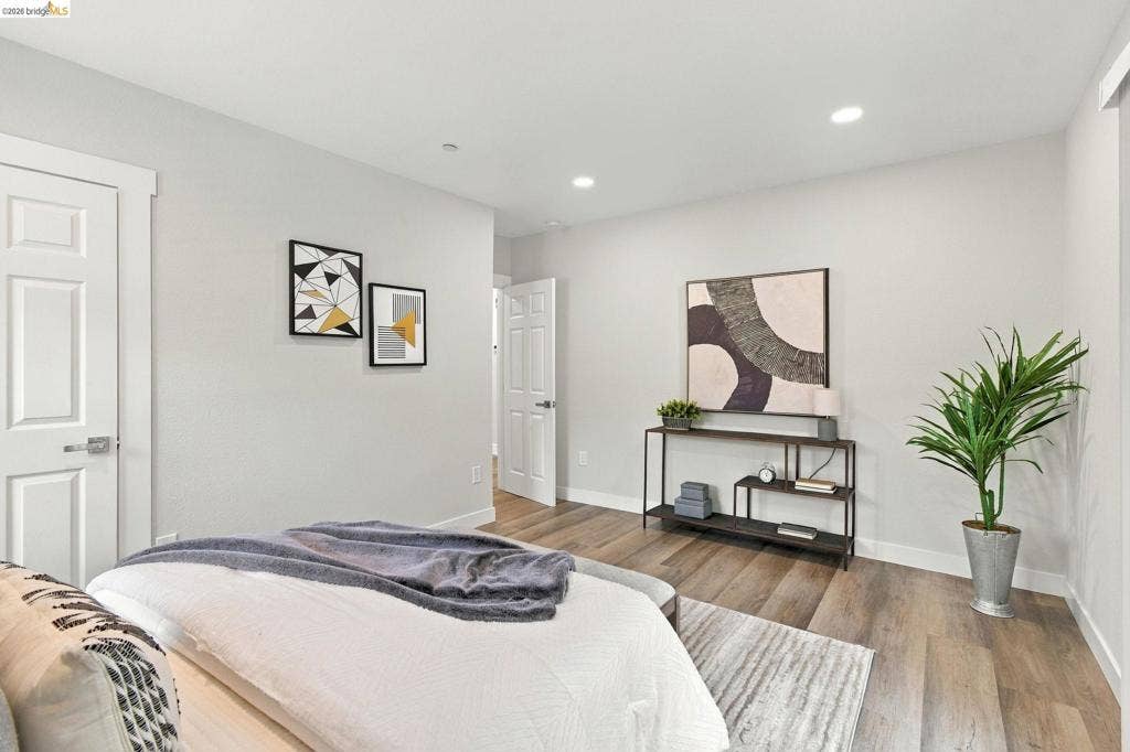 Light gray painted walls, wood-finish flooring, recessed ceiling lighting, and white interior doors
