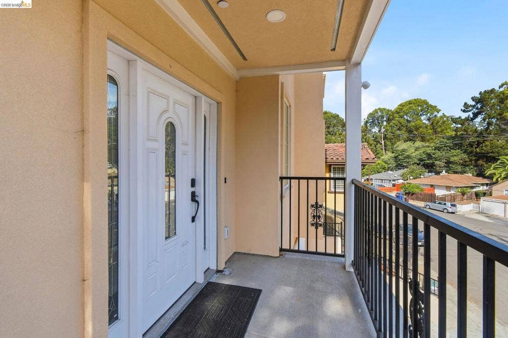Entryway with a white paneled door featuring decorative glass inserts, sidelights, and black hardware