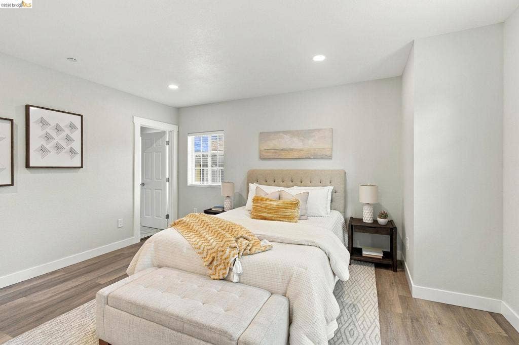Recessed lighting, light-toned walls, wood-finish flooring, and white trim