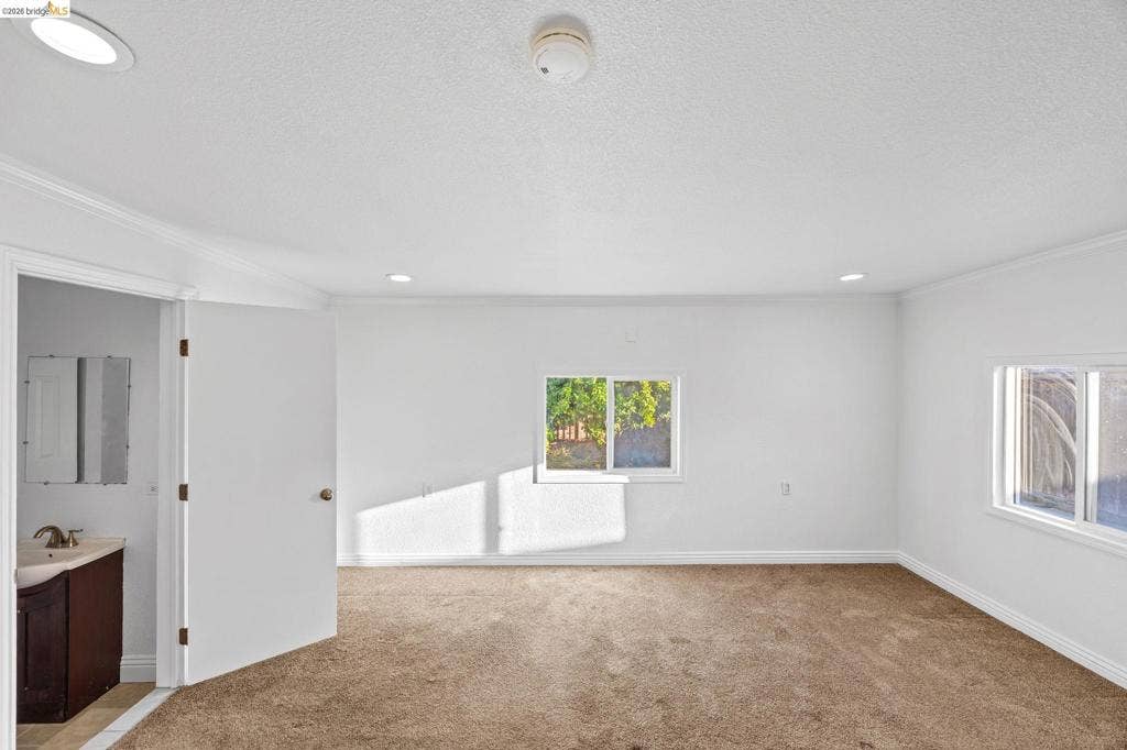 2240 Lessley Ave, Castro Valley, CA 94546 Recessed lighting, crown molding, white walls, two windows, and brown carpeting