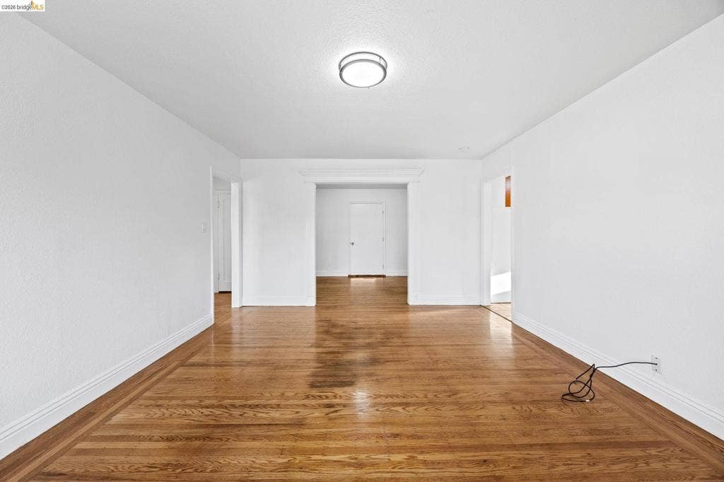 2240 Lessley Ave, Castro Valley, CA 94546 Hardwood flooring with border inlay, white walls, flush mount ceiling fixture, and multiple doorways