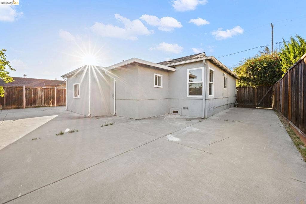 2240 Lessley Ave, Castro Valley, CA 94546 Exterior featuring a concrete patio, wood fencing, and multiple windows