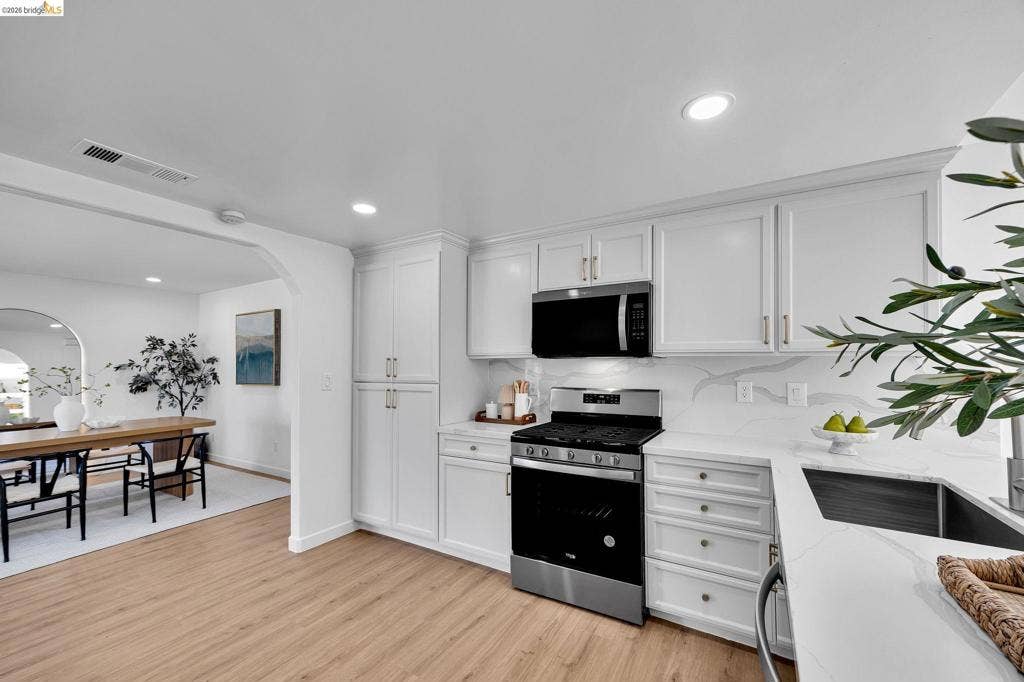 1509 Poppy Way, Antioch, CA 94509 Contemporary kitchen featuring white cabinetry, stainless steel appliances, light-toned wood-finish flooring, and recessed lighting