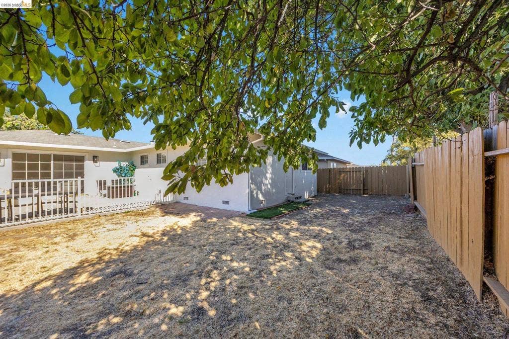 1509 Poppy Way, Antioch, CA 94509 Expansive outdoor space featuring a full perimeter fence, mature trees, and a paved patio area
