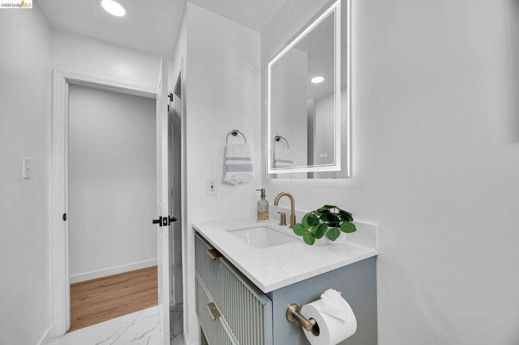 1509 Poppy Way, Antioch, CA 94509 Vanity with an integrated sink, gold-finish faucet, and an illuminated mirror