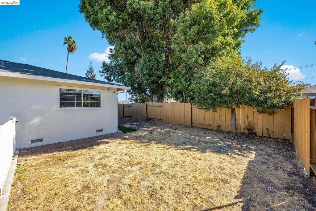 1509 Poppy Way, Antioch, CA 94509 Spacious rear yard with a perimeter wood fence, brick paver patio, and mature trees