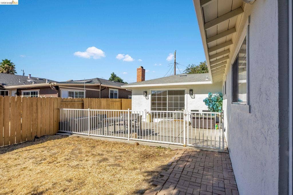 1509 Poppy Way, Antioch, CA 94509 Brick paver patio with white metal fencing, wood privacy fence, and sliding glass door access